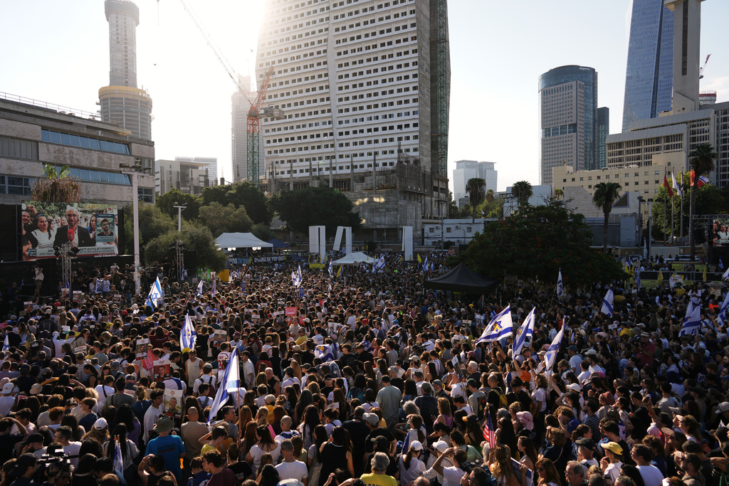 People gather to watch a live broadcast of Israeli hostages released from Gaza at a plaza known as hostages square in Tel Aviv, Israel, Monday, Oct. 13, 2025. The release took place as part of a cease-fire agreement between Israel and Hamas. (AP Photo/Oded Balilty)