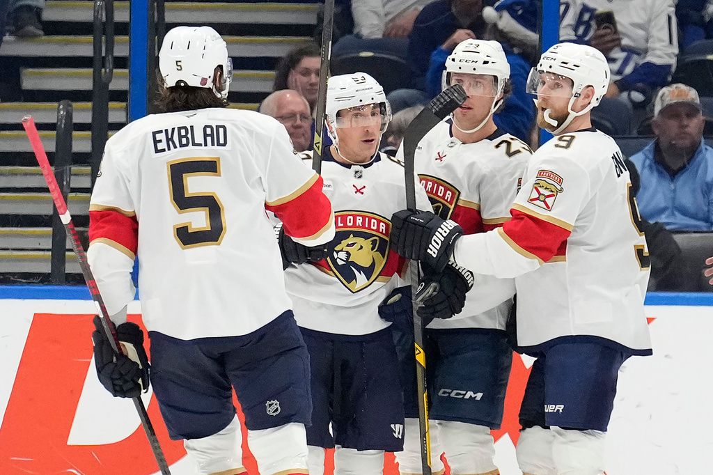 Florida Panthers left wing Brad Marchand (63) celebrates his goal against the Tampa Bay Lightning with defenseman Aaron Ekblad (5), center Carter Verhaeghe (23) and center Sam Bennett (9) during the second period of an NHL hockey game Monday, Dec. 15, 2025, in Tampa, Fla. (AP Photo/Chris O'Meara)
