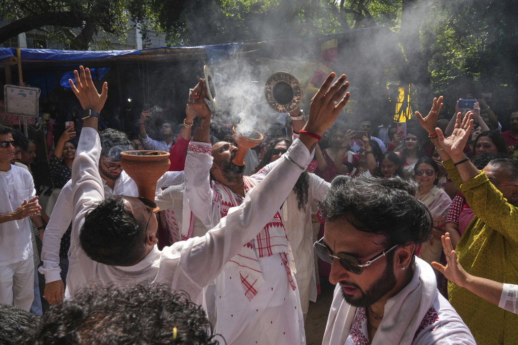 Devotees sing and dance as they gather at a temporary shelter to take an idol of the Hindu goddess Durga to their place of worship ahead of the Durga Puja festival in New Delhi, India, Sunday, Sept. 21, 2025. (AP Photo/Manish Swarup)