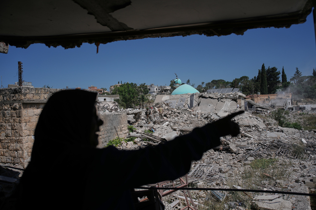 Mahasen Faqih gestures toward the rubble of her neighborhood from inside her destroyed home after returning to it following the Israeli military operation in Zawtar al-Gharbieh, Lebanon, Tuesday, July 28, 2026. (AP Photo/Hassan Ammar)