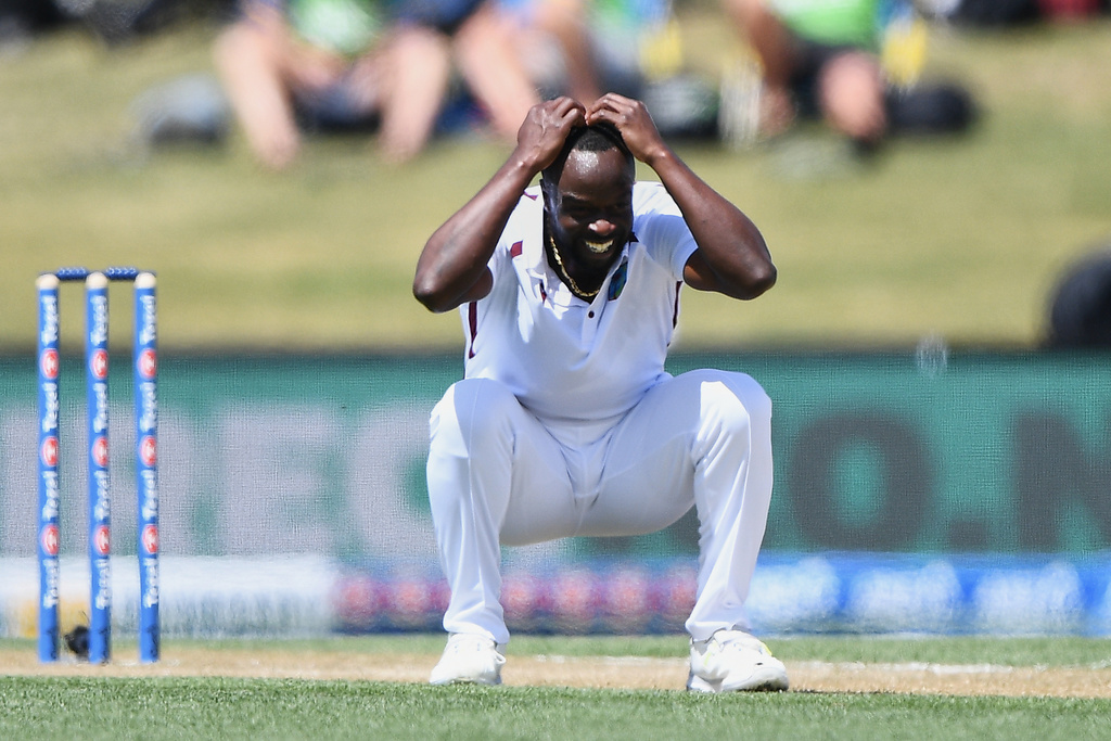 West Indies' Kemar Roach crouches after bowling against New Zealand on day 3 during their cricket test match in Christchurch, New Zealand, Thursday, Dec. 4, 2025. (Chris Symes/Photosport via AP)