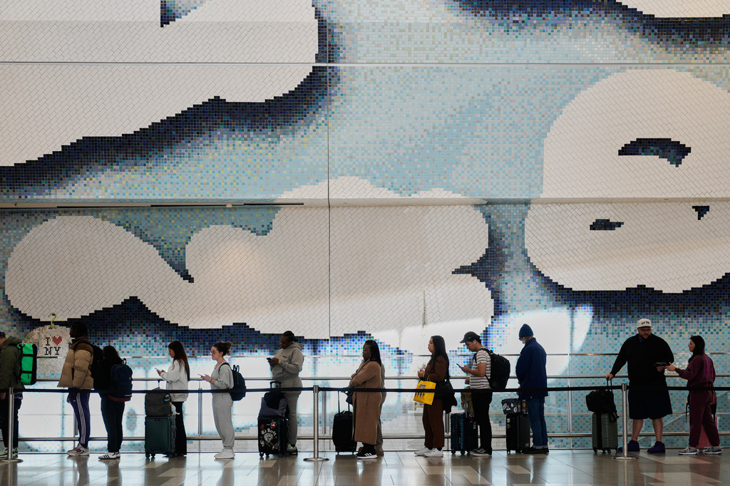 Travelers wait in a lines to get through security at LaGuardia Airport in New York, Monday, March 30, 2026. (AP Photo/Seth Wenig)