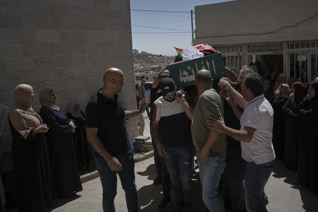 Mourners carry the body of Mohammad Alawi, 21, who according to Palestinian health officials died after being shot by settlers, during his funeral in the West Bank town of Deir Jarir, Sunday, Sept. 14, 2025. (AP Photo/Mahmoud Illean)