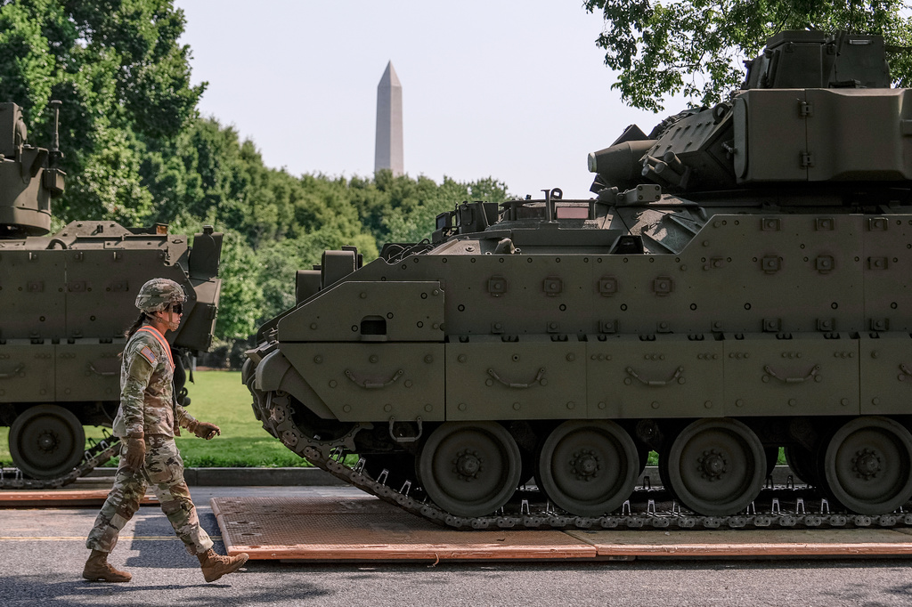FILE - A U.S. Army soldier walks past a Bradley fighting vehicle staged in West Potomac Park ahead of an upcoming military parade commemorating the Army's 250th anniversary and coinciding with Donald Trump's 79th birthday, June 11, 2025, in Washington. (AP Photo/Julia Demaree Nikhinson, File)