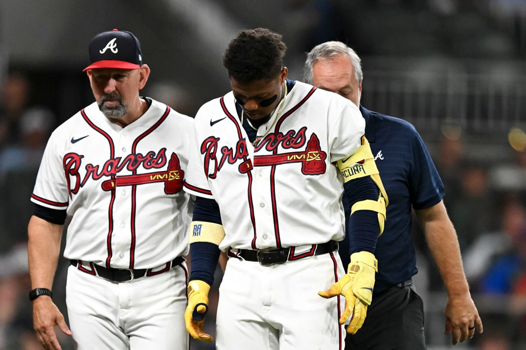 Atlanta Braves manager Walt Weiss (22) and outfielder Ronald Acuña Jr. (13) walk to the dugout after Acuña was injured during third inning of a baseball game against the Cincinnati Reds, Tuesday, Sept. 22, 2026, in Atlanta. (Daniel Varnado/Atlanta Journal-Constitution via AP)