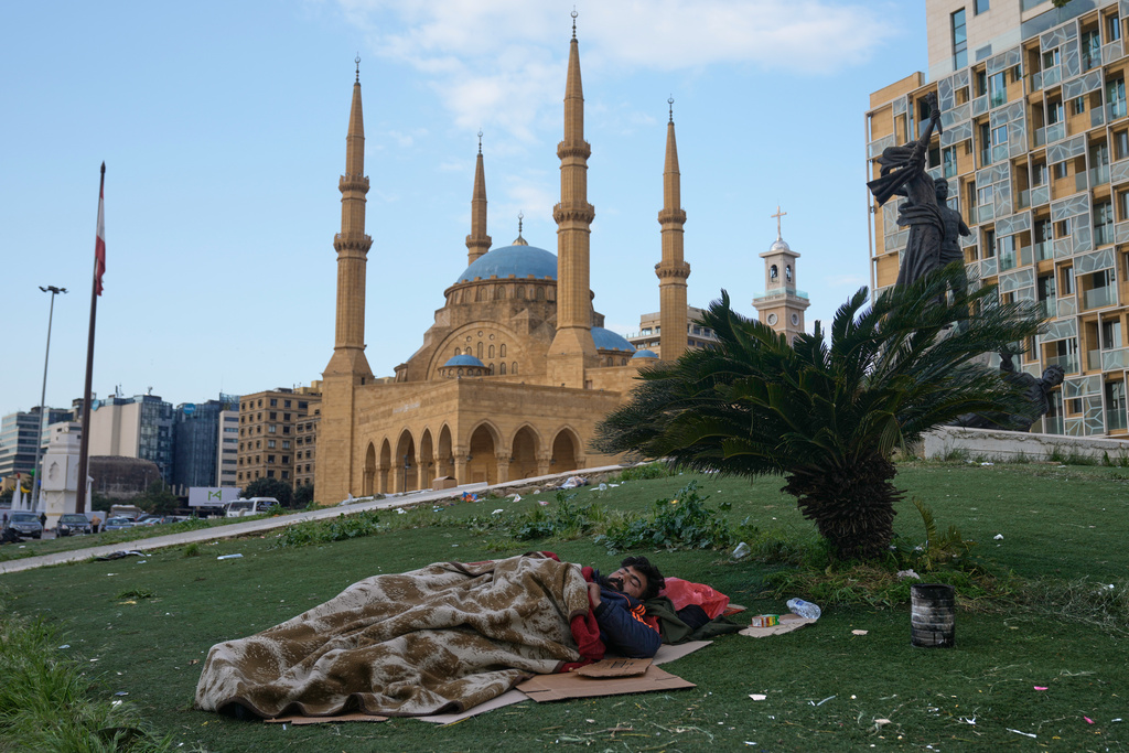 A displaced man who fled Israeli airstrikes in Dahiyeh, Beirut's southern suburbs, sleeps at Martyrs' Square in downtown Beirut, Lebanon, Saturday, March 7, 2026. (AP Photo/Bilal Hussein)