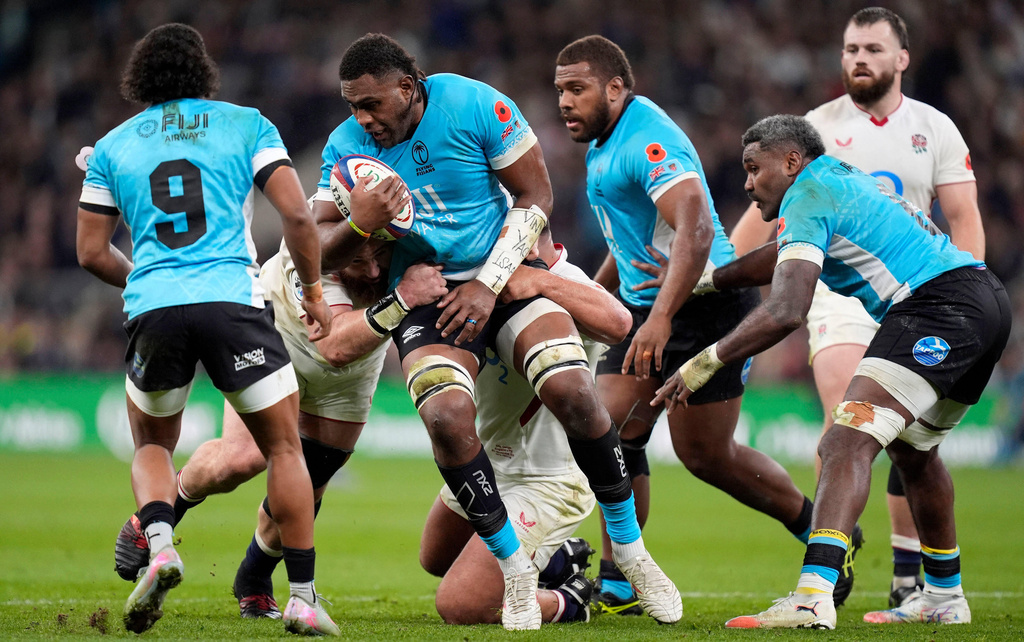 Fiji's Viliame Mata, center, is tackled by England's Joe Heyes, left, and Ellis Genge, right, during the Quilter Nations Series rugby match between England and Fiji in London, England, Saturday, Nov. 8, 2025. (Adam Davy/PA via AP)