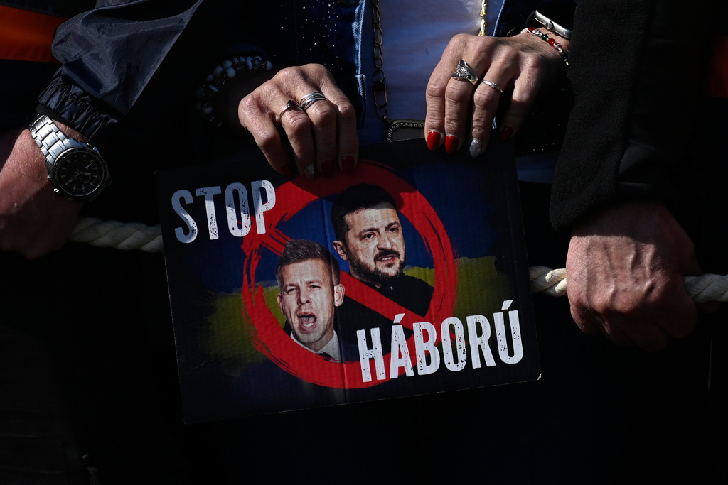 A supporter of Prime Minister Viktor Orban holds a placard reading "Stop the War" during a march in Budapest, Hungary, Sunday, March 15, 2026. (AP Photo/Denes Erdos)