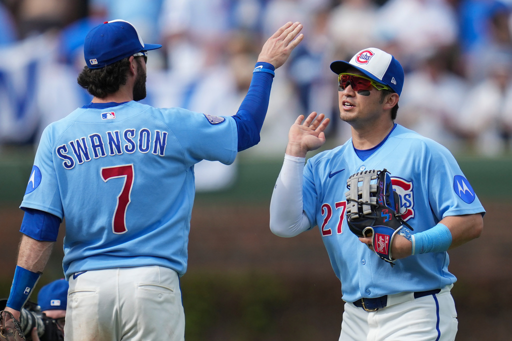 Chicago Cubs' Dansby Swanson (7) and Seiya Suzuki (27) celebrate their team's win over the New York Mets in a baseball game Friday, April 17, 2026, in Chicago. (AP Photo/Erin Hooley)