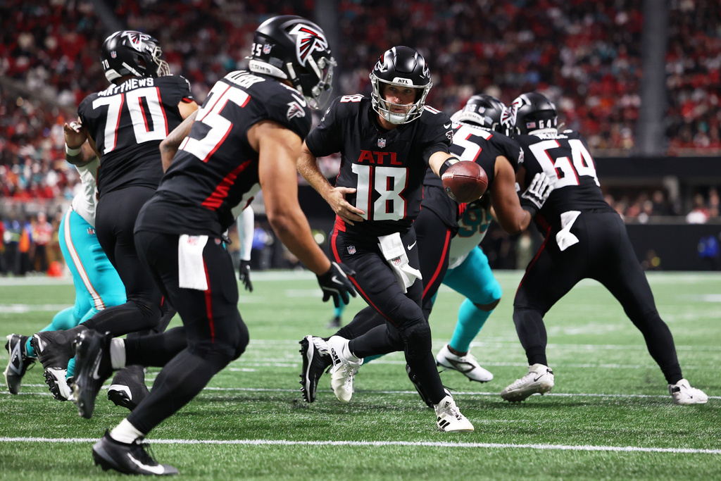 Atlanta Falcons quarterback Kirk Cousins (18) hands off the football during the first half of an NFL football game against the Miami Dolphins, Sunday, Oct. 26, 2025, in Atlanta. (AP Photo/Colin Hubbard)