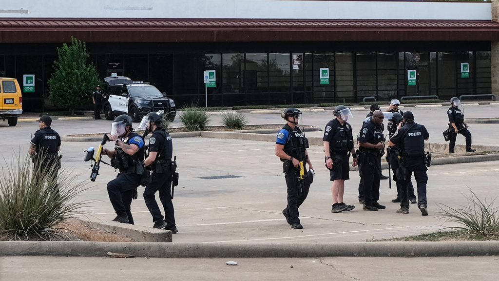 Authorities stand near the scene where a man was shot in his vehicle by an ICE officer, Sunday, Sept. 20, 2026, in Austin, Texas. (AP Photo/Joel Angel Juarez)
