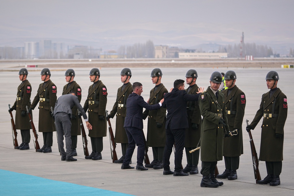 A Turkish honor guard prepares ahead of the arrival of the papal plane carrying Pope Leo XIV at Esenboga International Airport in Ankara, Turkey, Thursday, Nov. 27, 2025, marking the start of his first foreign trip. (AP Photo/Khalil Hamra)