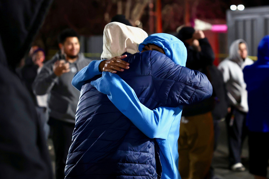 FILE - People hug each other after a fatal shooting in a parking lot of The Church of Jesus Christ of Latter-day Saints in Salt Lake City on Wednesday, Jan. 7, 2026. (Laura Seitz/The Deseret News via AP,File)