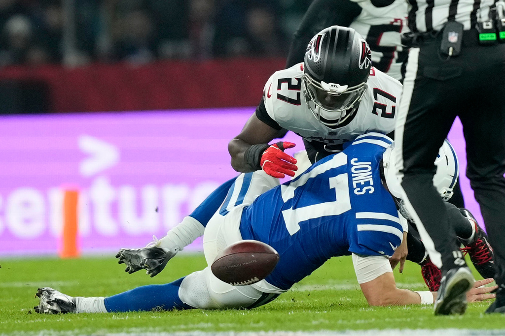 Indianapolis Colts quarterback Daniel Jones (17) fumbles as he is hit by Atlanta Falcons linebacker James Pearce Jr. (27) during the second half of an NFL football game, Sunday, Nov. 9, 2025, in Berlin, Germany. (AP Photo/Ebrahim Noorozi)