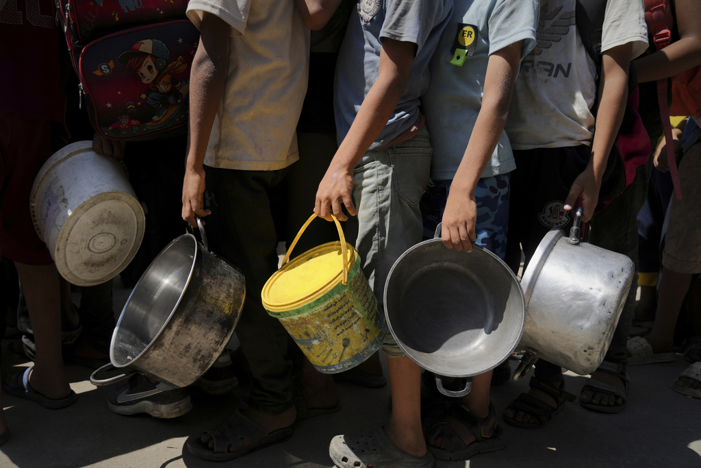 Palestinians line up to receive donated food at a community kitchen in Deir al-Balah, southern Gaza Strip, Saturday, Sept. 6, 2025. (AP Photo/Jehad Alshrafi)