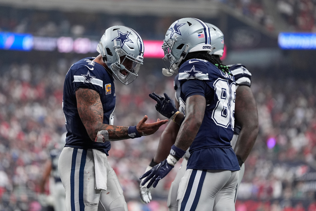 Dallas Cowboys wide receiver Ceedee Lamb, right, celebrates his touchdown with quarterback Dak Prescott during the second half of an NFL football game against the Houston Texans in Houston, Sunday, Oct. 4, 2026. (AP Photo/Ashley Landis)