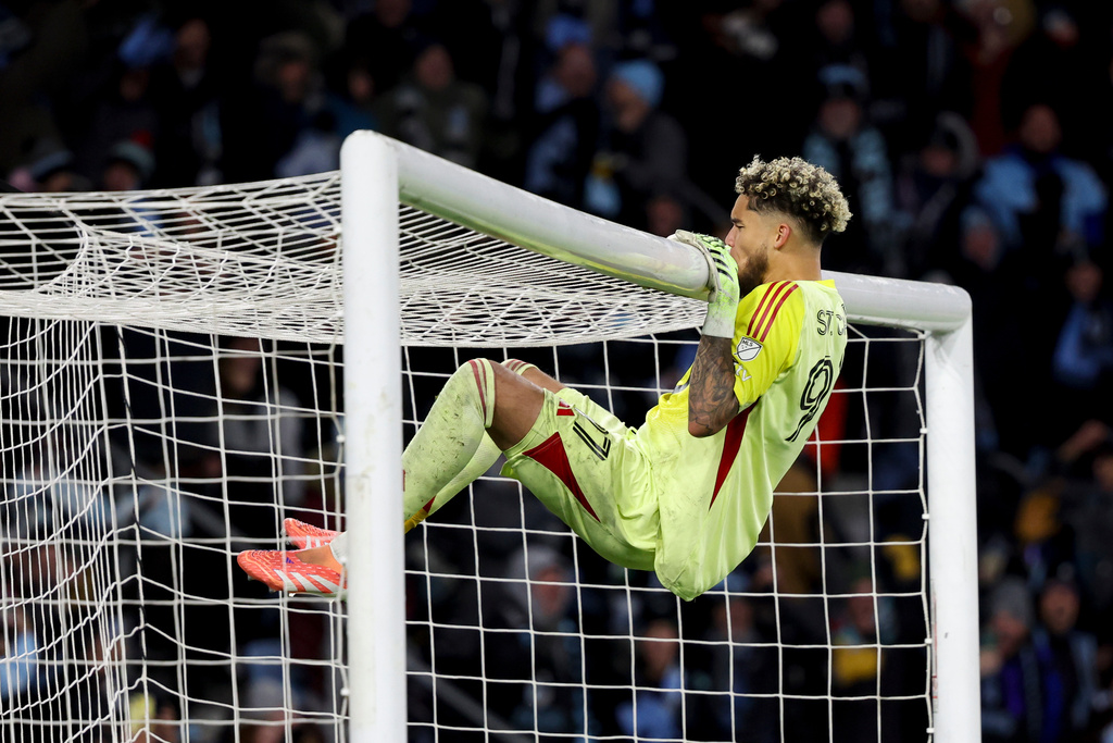 Minnesota United goalkeeper Dayne St. Clair kisses the goal after the Seattle Sounders missed a score in a penalty shootout to end the Game 3 in the first round of MLS soccer's Western Conference playoffs in St. Paul, Minn., Saturday, Nov. 8, 2025. (AP Photo/Ellen Schmidt)