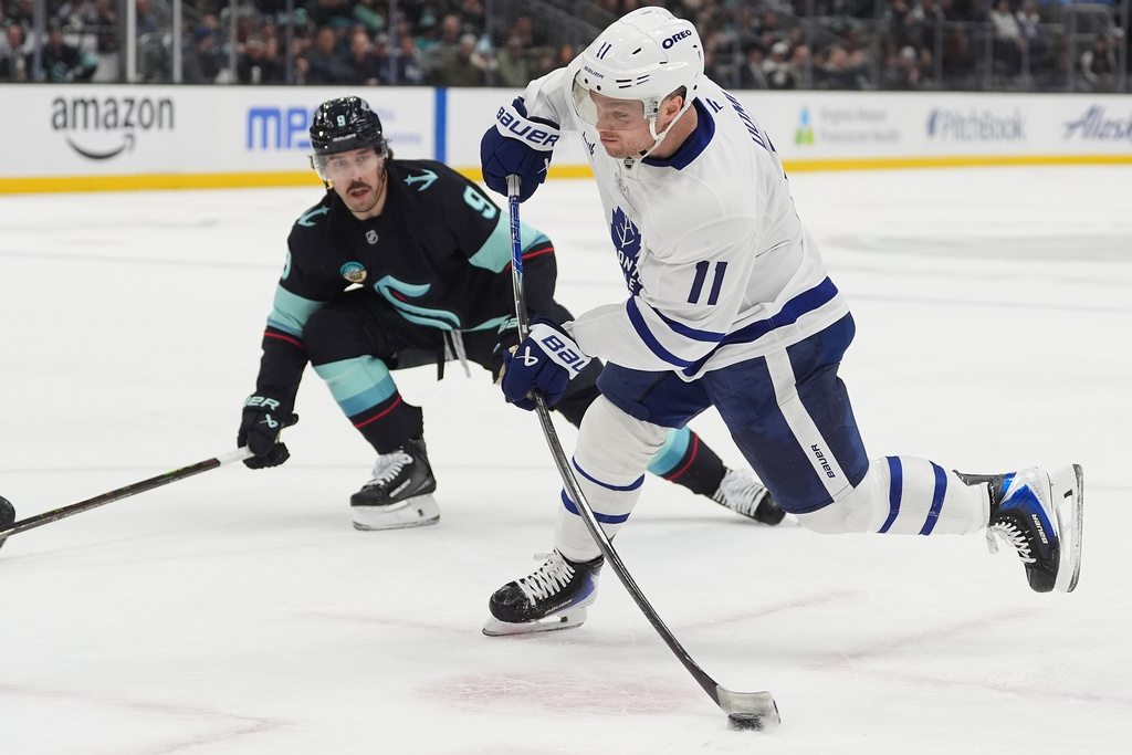 Toronto Maple Leafs center Max Domi (11) shoots as Seattle Kraken center Chandler Stephenson (9) looks on during the second period of an NHL hockey game Thursday, Jan. 29, 2026, in Seattle. (AP Photo/Lindsey Wasson)