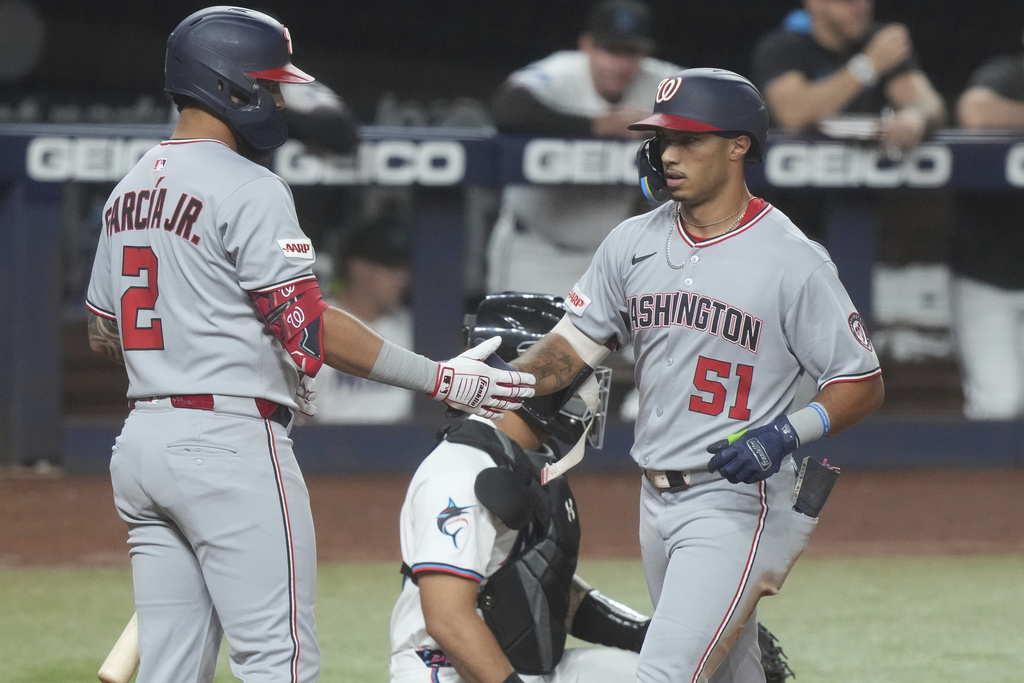 Washington Nationals' Luis García Jr. (2) congratulates Daylen Lile (51) after Lile hit a home run during the fifth inning of a baseball game against the Miami Marlins Tuesday, Sept. 9, 2025, in Miami. (AP Photo/Marta Lavandier)
