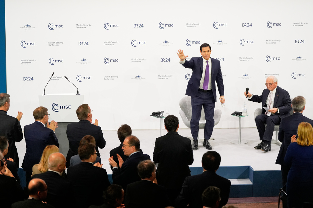 U.S. Secretary of State Marco Rubio waves, next to Chairman of the Munich Security Conference Wolfgang Ischinger, as he gets a standing ovation after his speech at the Munich Security Conference in Munich, Germany, Saturday, Feb. 14, 2026. (AP Photo/Alex Brandon, Pool)