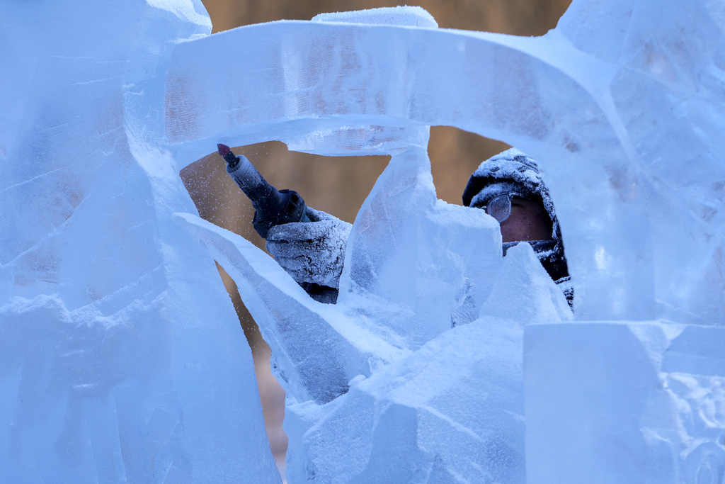 An artist works on an ice sculpture during the National Professional Ice Sculpture Contest at the Harbin Ice and Snow World in Harbin, China's Heilongjiang province on Wednesday, Jan. 8, 2025. (AP Photo/Andy Wong)