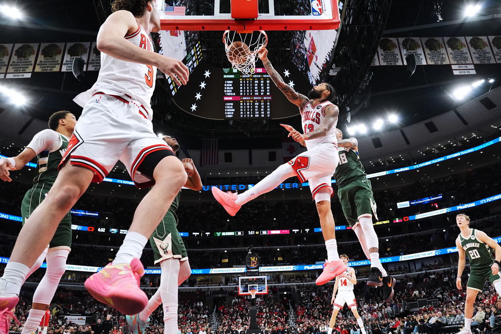 Chicago Bulls center Nick Richards (13) dunks past Milwaukee Bucks forward Kyle Kuzma (18) during the second half of an NBA basketball game in Chicago, Sunday, March 1, 2026. (AP Photo/Nam Y. Huh)