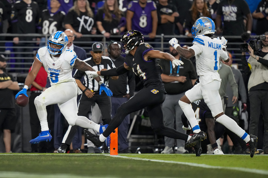 Detroit Lions running back David Montgomery, left, scores a touchdown as Baltimore Ravens safety Kyle Hamilton (14) tries to stop him during the second half of an NFL football game Monday, Sept. 22, 2025, in Baltimore. (AP Photo/Stephanie Scarbrough)