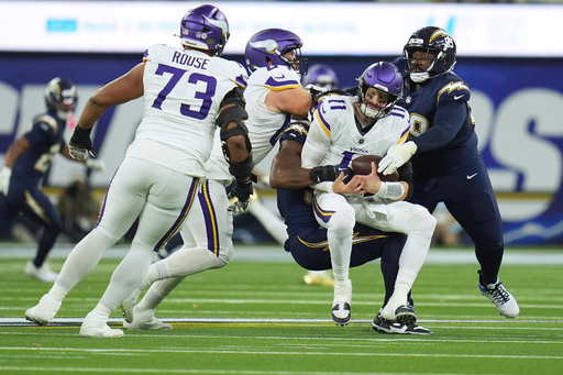 Minnesota Vikings quarterback Carson Wentz (11) is sacked by Los Angeles Chargers linebacker Odafe Oweh (98), middle, and defensive tackle Jamaree Caldwell (99), right, during the first half of an NFL football game Thursday, Oct. 23, 2025, in Inglewood, Calif. (AP Photo/Gregory Bull) Minnesota Vikings quarterback Carson Wentz (11) is sacked by Los Angeles Chargers linebacker Odafe Oweh (98), middle, and defensive tackle Jamaree Caldwell (99), right, during the first half of an NFL football game Thursday, Oct. 23, 2025, in Inglewood, Calif. (AP Photo/Gregory Bull)