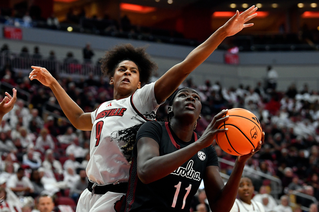 Louisville forward Anaya Hardy (9) attempts to block a shot-attempt by South Carolina center Madina Okot (11) during the first half of an NCAA college basketball game in Louisville, Ky., Thursday, Dec. 4, 2025. (AP Photo/Timothy D. Easley)