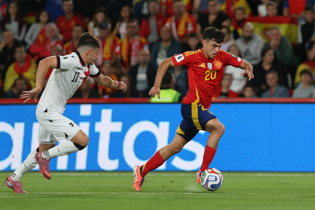 FILE - Spain's Pedri, right, dribbles the ball followed by Georgia's Giorgi Gocholeishvili during a World Cup 2026 qualifying soccer match between Spain and Georgia at Manuel Martinez Valero stadium in Elche, Spain, Saturday, Oct. 11, 2025. (AP Photo/Alberto Saiz, File)