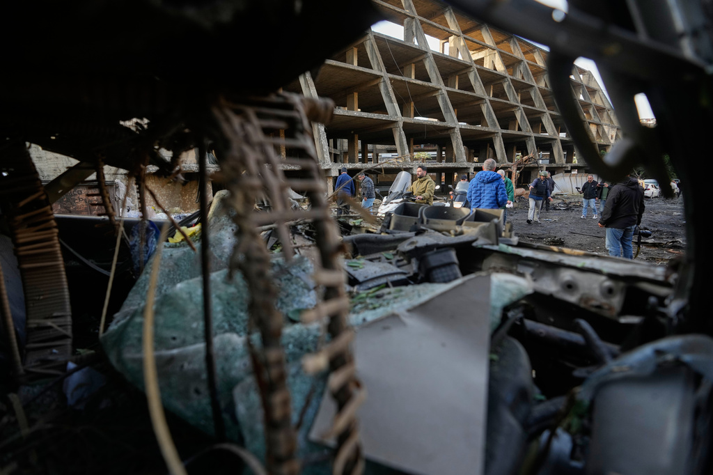 People inspect the site of an Israeli strike amid debris and damaged vehicles in Beirut, Lebanon, Wednesday, April 1, 2026. (AP Photo/Hassan Ammar)