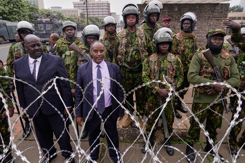 Police stand guard around parliament during a demonstration to mark two years since more than 60 people died in anti-government protests that resulted in the storming of the parliament, in Nairobi, Kenya, Thursday, June 25, 2026. (AP Photo/Brian Inganga)