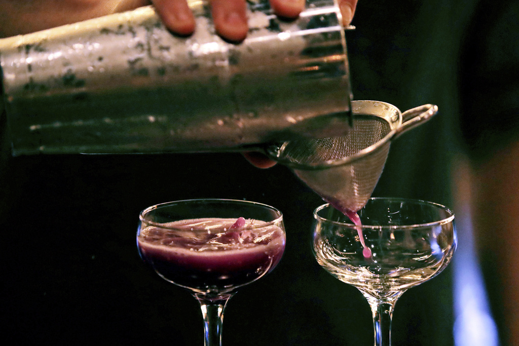 FILE - A bartender pours a cocktail in Dec. 10, 2019, in Boston. (AP Photo/Charles Krupa, File)