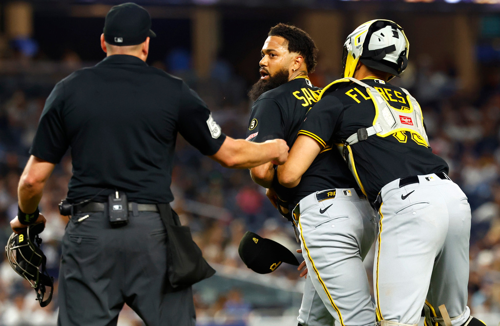 Pittsburgh Pirates catcher Rafael Flores Jr. keeps pitcher Dennis Santana from going after New York Yankees' José Caballero during the ninth inning of a baseball game, Monday, July 20, 2026 in New York. (AP Photo/Noah K. Murray)