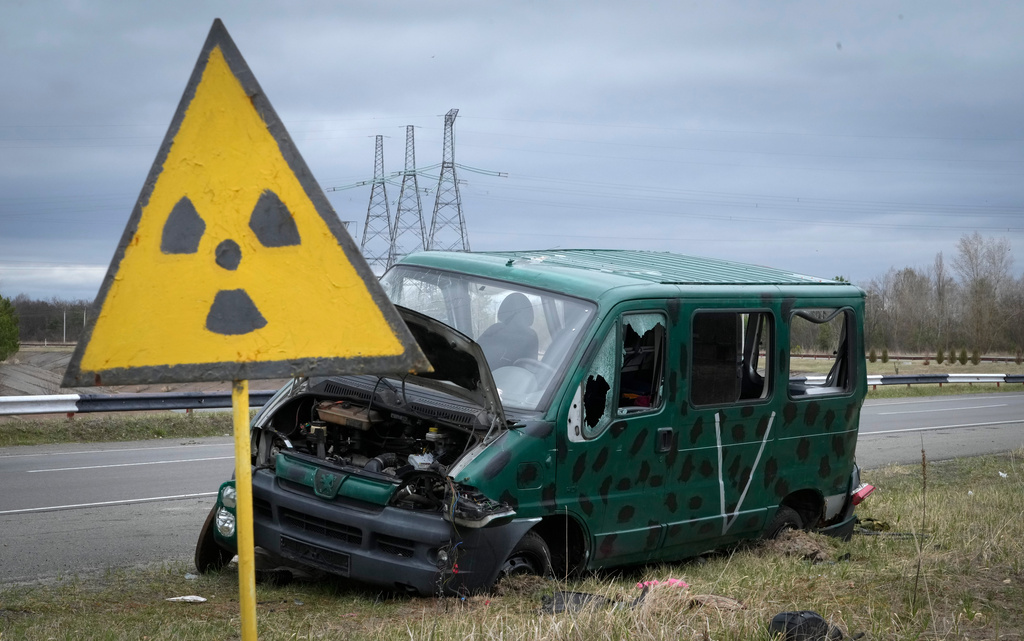FILE - A radiation sign stands near the remains of a vehicle belonging to the Russian military near the Chernobyl nuclear power plant in Chernobyl, Ukraine, April 16, 2022. (AP Photo/Efrem Lukatsky, File)