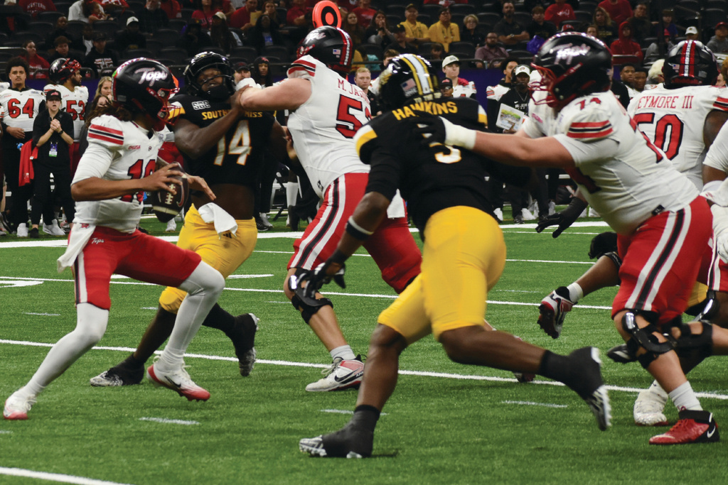 Western Kentucky Quarterback Maverick McIvor (7) looks down the field while being rushed by Southern Miss defenders J'Mond Tapp (14) and JJ Hawkins (5) during the first half of the NCAA college Football game the New Orleans Bowl on Tuesday, Dec. 23, 2025 in New Orleans, La. (Aimee Cronan/The Gazebo Gazette via AP)