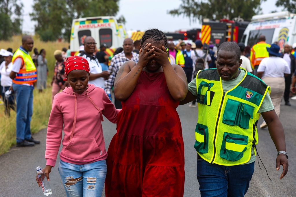 Relatives of school children who died when the minibus they were riding in collided with a truck, weep at the scene of the crash in Vanderbijlpark, South of Johannesburg, South Africa, Monday, Jan. 19, 2026. (AP Photo)