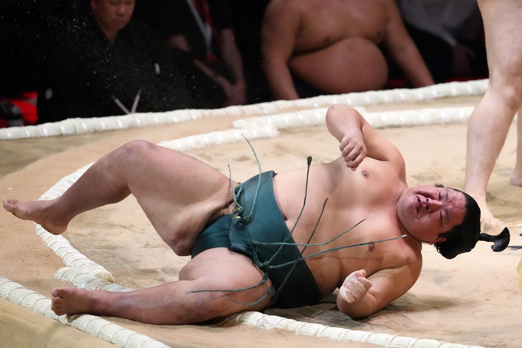 A Sumo wrestler lands on the edge of the ring during The Grand Sumo Tournament at the Royal Albert Hall in London, Wednesday, Oct. 15, 2025.(AP Photo/Frank Augstein)