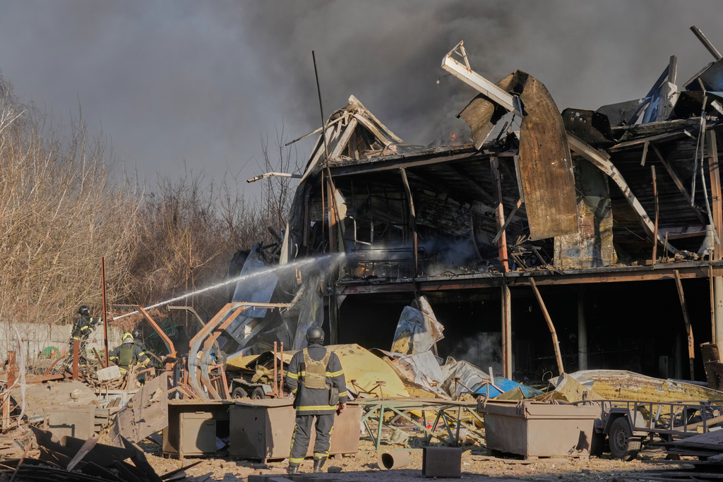 Firefighters put out the fire at railway workshops following a Russia missile and drone attack, in Brovary, close to Kyiv, Ukraine, Saturday, March 14, 2026. (AP Photo/Efrem Lukatsky)
