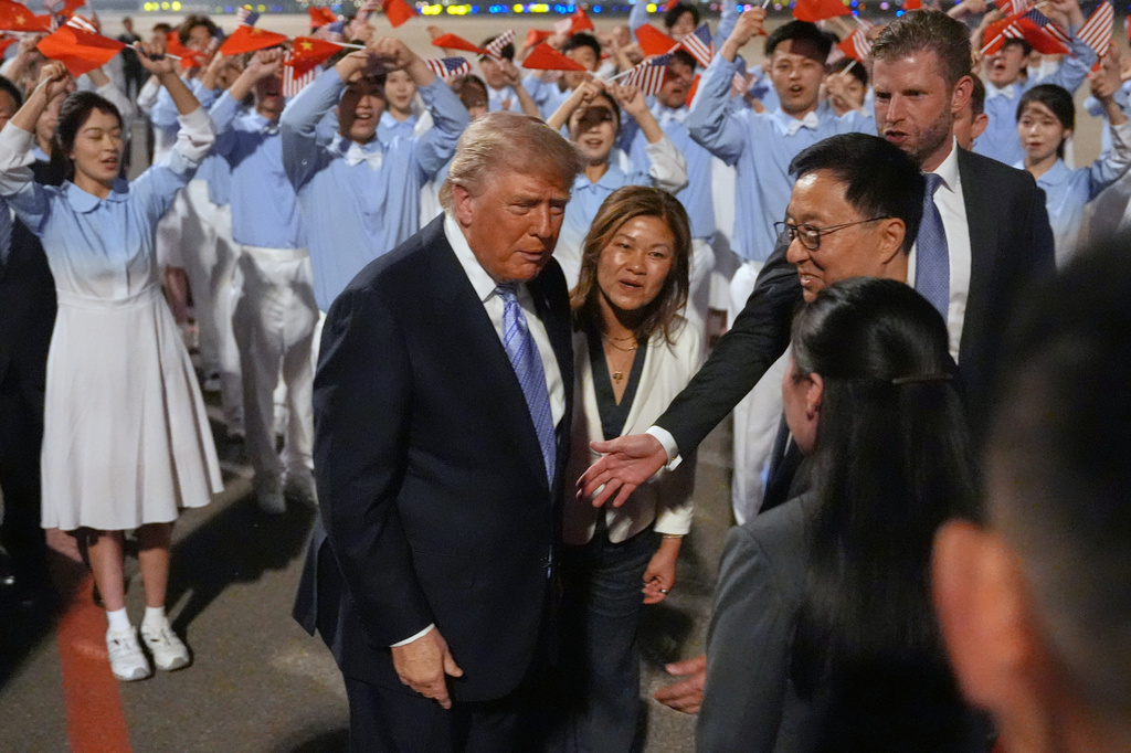 President Donald Trump talks during an arrival ceremony Wednesday, May 13, 2026, at Beijing Capital International Airport in Beijing, with Eric Trump, right. (AP Photo/Mark Schiefelbein)