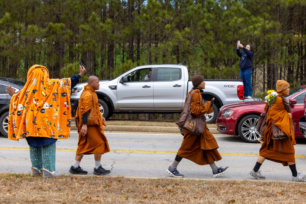 Supporters watch Buddhist monks on a "Walk for Peace" on Veterans Parkway in Fayetteville, Ga., on Monday, Dec. 29, 2025, from Texas to Washington, D.C. (Arvin Temkar/Atlanta Journal-Constitution via AP)