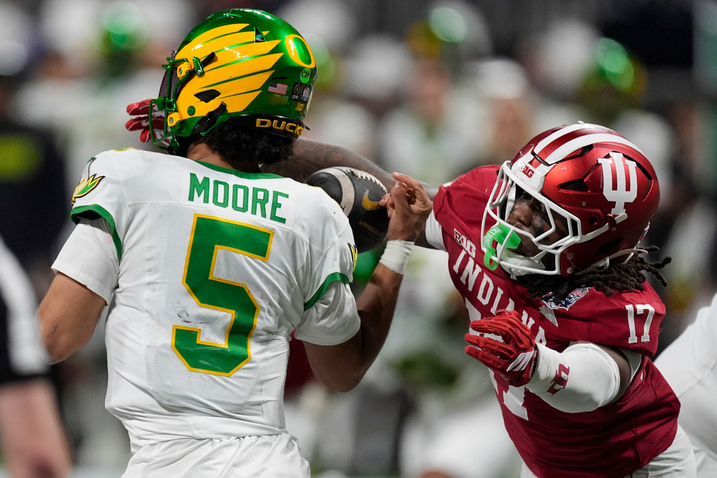 Indiana defensive lineman Daniel Ndukwe (17) pressures Oregon quarterback Dante Moore (5) during the first half of the Peach Bowl NCAA college football playoff semifinal, Friday, Jan. 9, 2026, in Atlanta. (AP Photo/Mike Stewart)