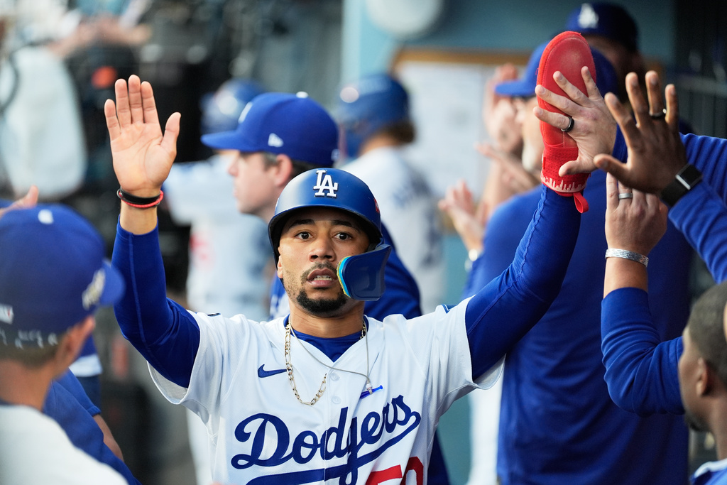 Los Angeles Dodgers' Mookie Betts celebrates in the dugout after scoring against the Milwaukee Brewers during the first inning in Game 4 of baseball's National League Championship Series, Friday, Oct. 17, 2025, in Los Angeles. (AP Photo/Ashley Landis)