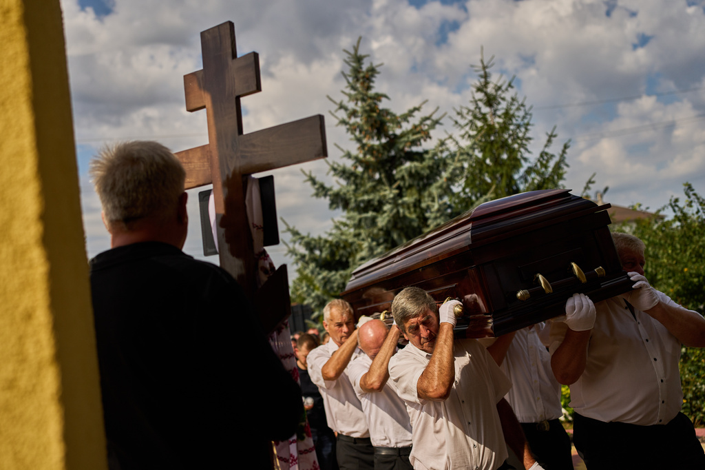 Pallbearers carry the coffin of Taras Didych, head of the Dmytrivska community in Kyiv region, who was killed while going to help local residents following a Russian drone attack during his funeral in Myla, on the outskirts of Kyiv, Monday, Aug. 31, 2026. (AP Photo/Francisco Seco)