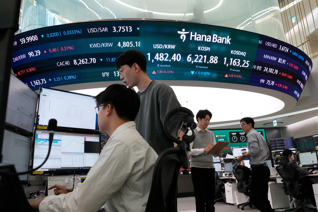Currency traders work near a screen showing the Korea Composite Stock Price Index (KOSPI), top center, and the foreign exchange rate between U.S. dollar and South Korean won, top center left, at the foreign exchange dealing room of the Hana Bank headquarters, in Seoul, South Korea, Friday, April 17, 2026. (AP Photo/Ahn Young-joon)