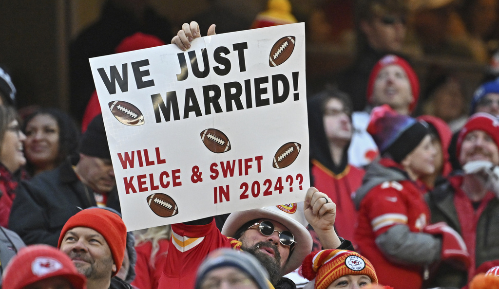 FILE - Fans hold up a sign about Kansas City Chiefs tight end Travis Kelce and Taylor Swift during an NFL football game between the Kansas City Chiefs and Cincinnati Bengals, Dec. 31, 2023, in Kansas City, Mo. (AP Photo/Peter Aiken)