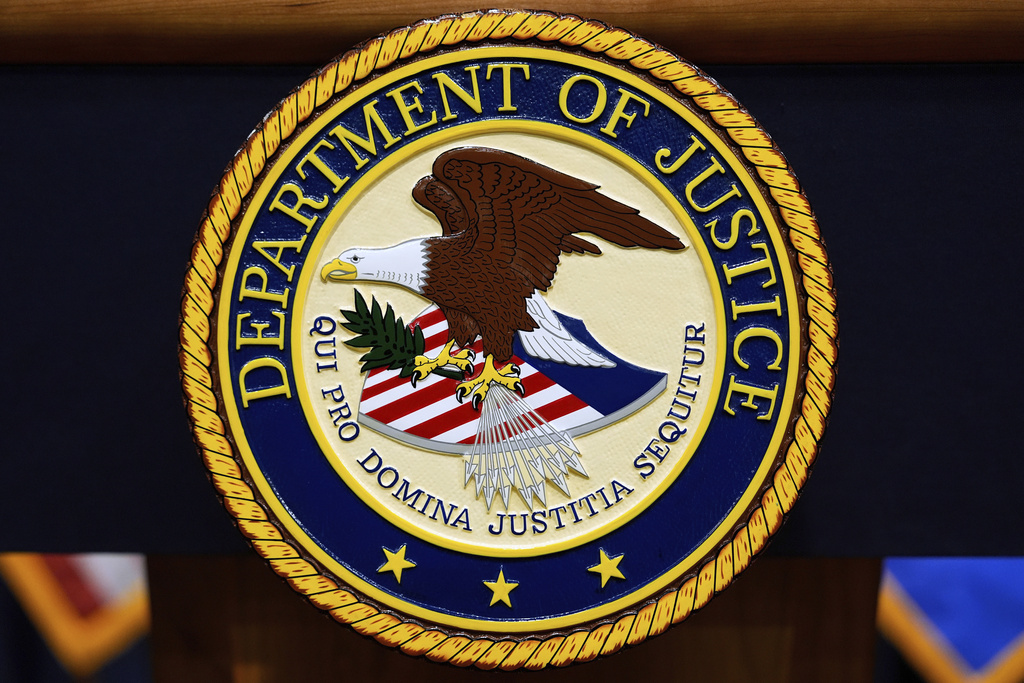 FILE - The U.S. Department of Justice logo is seen on a podium before a press conference, May 6, 2025, at the Justice Department in Washington. (AP Photo/Julia Demaree Nikhinson, File)
