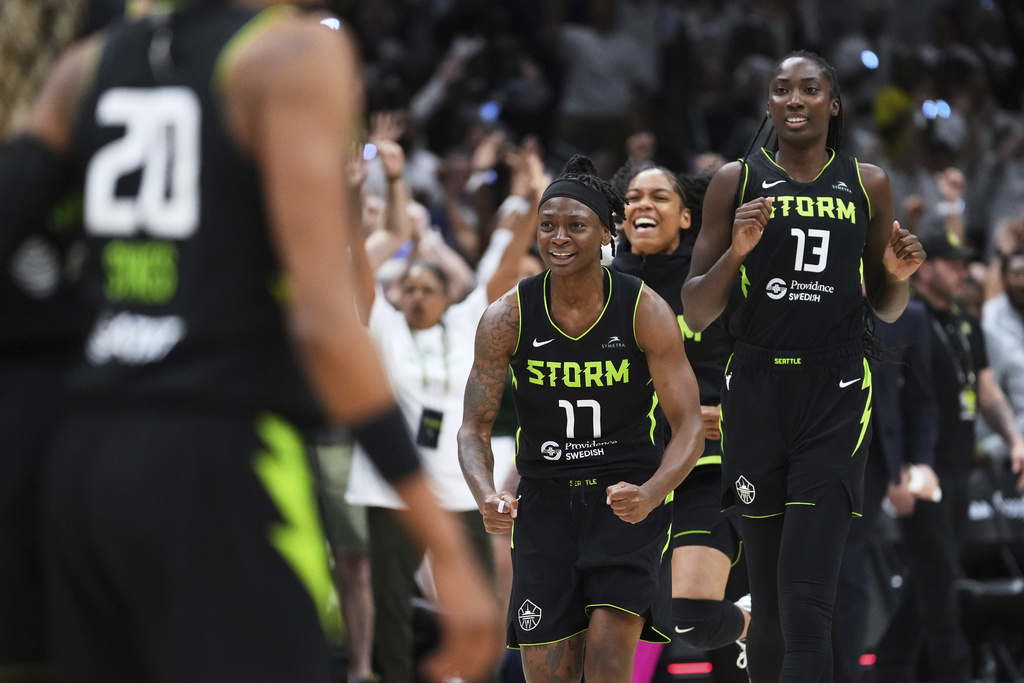 Seattle Storm guard Erica Wheeler (17) and forward Ezi Magbegor (13) run to greet teammates as the final buzzer rings and they beat the Las Vegas Aces in Game 2 in the first round of the WNBA basketball playoffs Tuesday, Sept. 16, 2025, in Seattle. (AP Photo/Lindsey Wasson)
