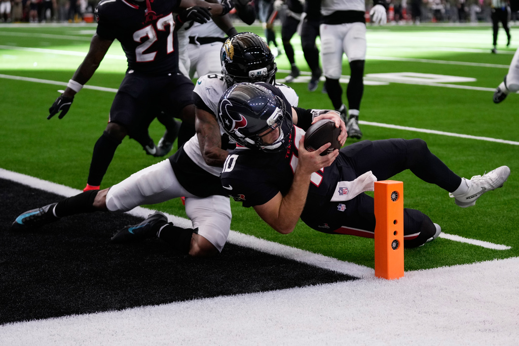 Houston Texans quarterback Davis Mills (10) scores a touchdown against Jacksonville Jaguars cornerback Greg Newsome II (6) during the second half of an NFL football game, Sunday, Nov. 9, 2025, in Houston. (AP Photo/Eric Christian Smith)