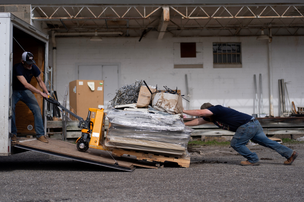 Ed Tierney, left, and David Horne, struggle to load an overloaded pallet onto a truck at they close up one of two JCD Bargain and Trade stores, to consolidate with the other location, in Ravenswood, W.Va., Friday, March 13, 2026. (AP Photo/Carolyn Kaster)